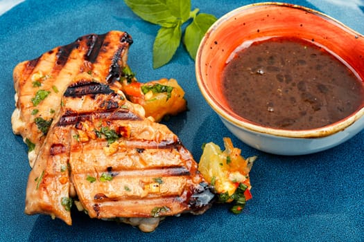 Cooked tuna steak with vegetables on a plate. Seafood.