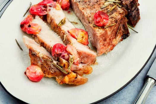 Delicious grilled beef steak with gooseberry on rustic wooden table.