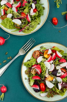 Tasty salad with radish, greens, tomato and sesame. Vegan recipe.