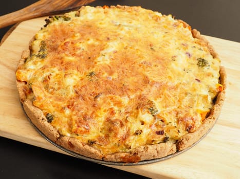 Tasty organic vegetable quiche on a cutting board in a kitchen, healthy eating or diet concept, vegetarian food