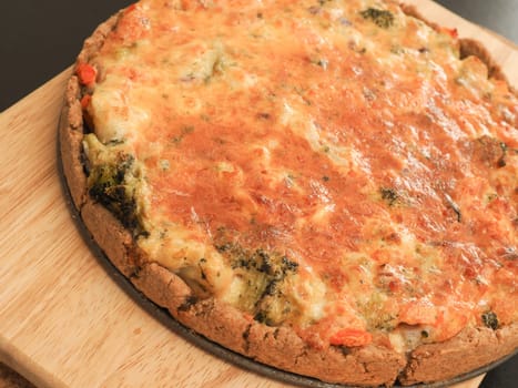 Tasty organic vegetable quiche on a cutting board in a kitchen, healthy eating or diet concept, vegetarian food