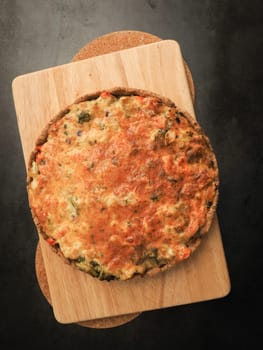 Tasty organic vegetable quiche on a cutting board in a kitchen, healthy eating or diet concept, vegetarian food