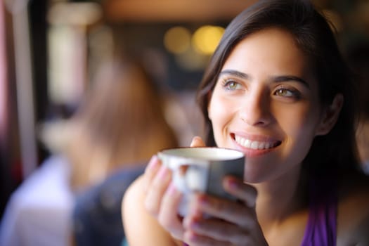 Happy dreamer dreaming drinking coffee in a restaurant interior