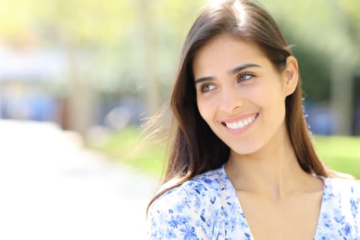 Portrait of a happy woman with perfect smile looking at side in the street
