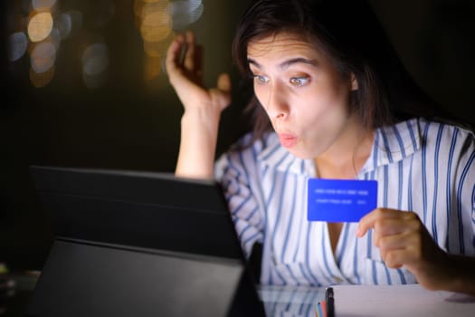 Amazed woman buying with tablet and credit card in the night at home