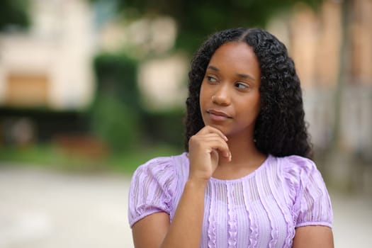 Pensive black woman wondering looking at side in the street