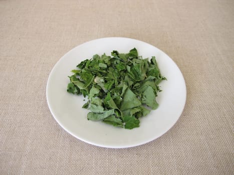 Dried garden nasturtium herbs on a white plate, Tropaeoli herba