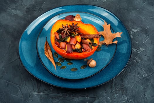 Half of the autumnal pumpkin or squash roasted with apples, peaches and cinnamon. Vegetarian autumn recipe