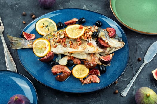 Baked dorado fish with almonds and figs. Autumn recipe. Space for text