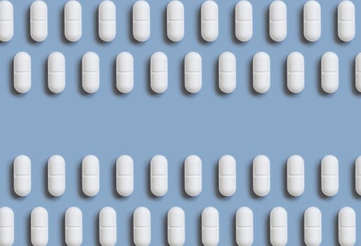 White pills on light blue top view, creative pattern. Curative medicine and healthcare, taking dietary supplements and vitamins. Pharmaceutical pills