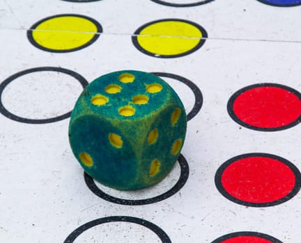 Green and red dice on the floor in a game of board games. A die indicates the six.