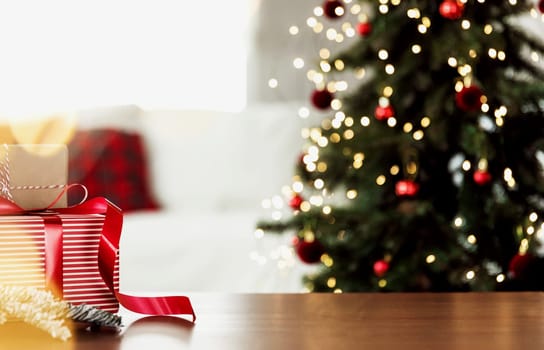 Christmas, New Year background with copy space for design. Empty wooden tabletop surface, blurred Christmas fir tree composition, bokeh sparkle lights effect. Mockup ready for product montage