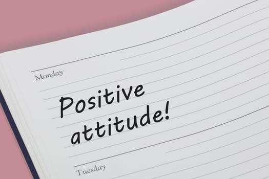 A Positive attitude diary reminder open on desk