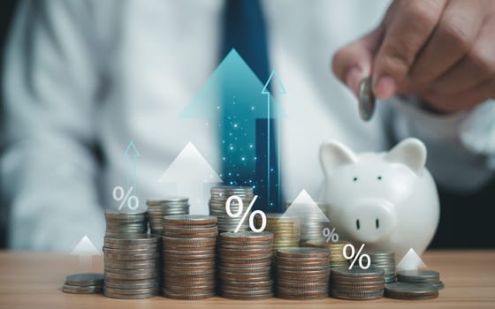 Coins are lined up on a wooden floor along with arrows and percent icon. Represents financial, economic, business growth concepts. Financial success concept.
