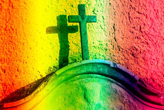Christian cross on a tombstone in LGBTQ colors