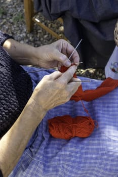 Detail of woman sewing wool by hand, ancient tradition