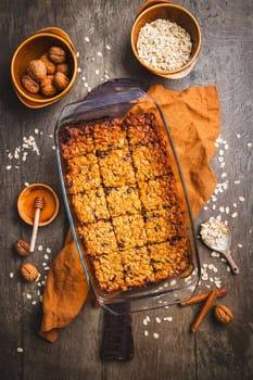 Vegan oatmeal banana bread or case with nuts on wooden kitchen table