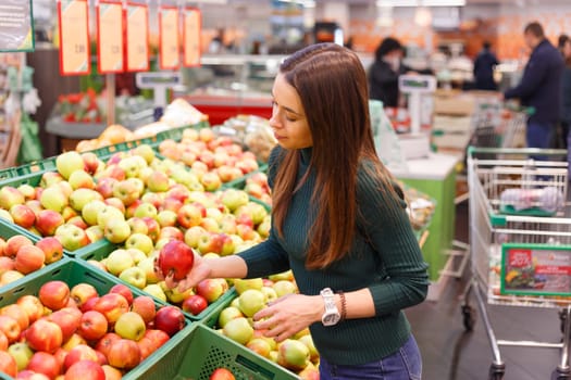 Young woman buy apples in farm food store.