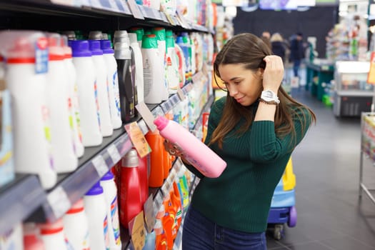 Woman choosing laundry detergent in grocery store