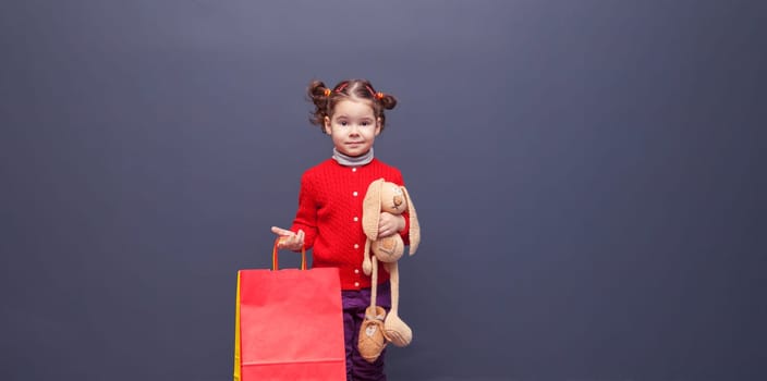 Beautiful little girl with colorful paper bags.
