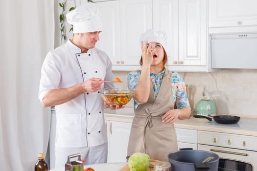 Funny senior chef cooks a tasting salad. Delicious