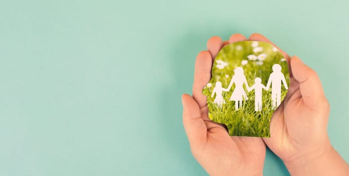 Parents with children walking on a meadow and holding hands, relationship in family, care and security concept, charity and insurance