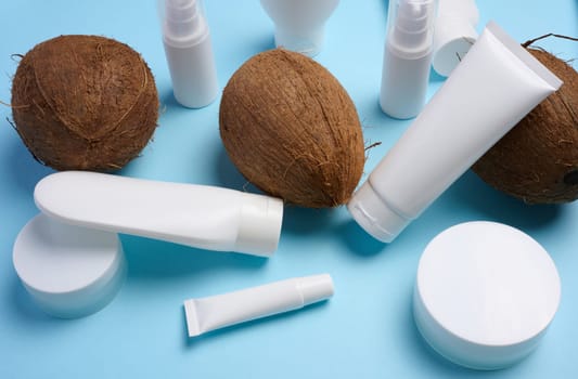 White plastic tubes, jars, and containers for cosmetic products on a blue background, advertising and branding of products