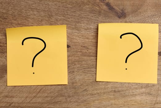 Orange stickers with a question mark on a wooden board
