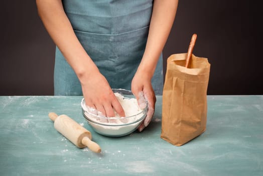 Baker kneading dough for artisan bread or pizza with his hands, prepare ingredients for food, baking pastry