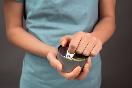 Opening a tin can with preserved food, box with tuna fish, processed ingredients, feeding a pet