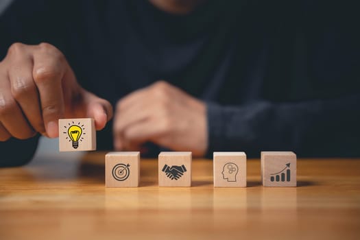 Business success and support through consulting. Wood block with glowing light bulb icon on hand against. New initiative and strategy brainstorm for digital transformation. Creative inspiration