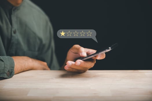 Unhappy client uses smartphone to give a 1-star satisfaction rating on social media. Negative feedback concept impacting business reputation and customer perception.