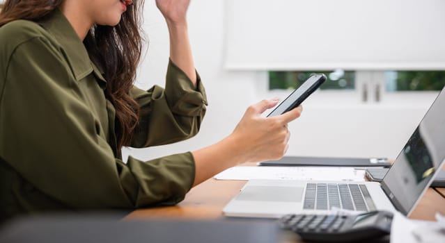 Asian young woman pay for goods digital payment success on smartphone, Smile female buy product on laptop computer she pay money by mobile phone, Easy E-commerce shopping online, lifestyles technology