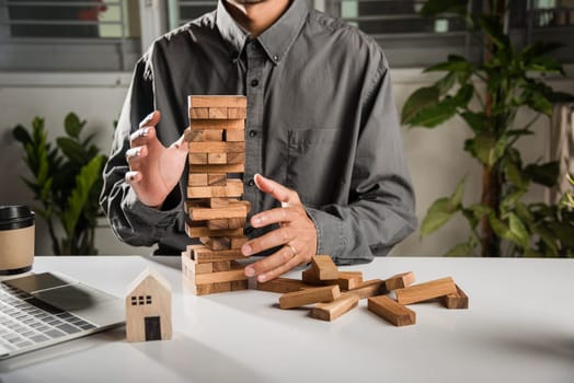 Hand of engineer man protection blocks wood tower, Hands stop domino effect before destroy home before fail, business risking dangerous project, Insurance concept