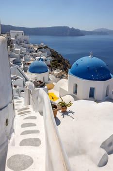 Oia, Santorini, Greece - July 3, 2021: View from viewpoint of Oia village with blue dome of  greek orthodox Christian church. Santorini, Greece