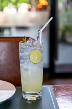 This glass of lemon soda is clear, filled with light yellow lemon soda. There are chunks of ice floating on top. On the side of the glass, thin slices of lemon floated, reminiscent of the fresh scent.