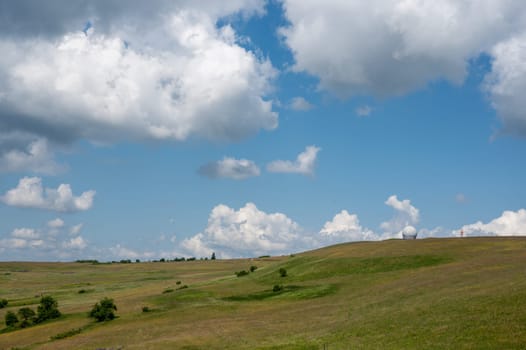 Radome (antenna dome) on the Wasserkuppe with a green meadow and blue sky and copy space