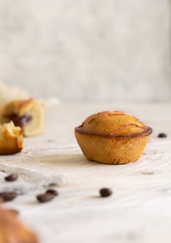 Pasticciotto leccese pastry filled with egg custard cream. Pasticiotties on a white wooden table, close up. Table decorated with coffee beans