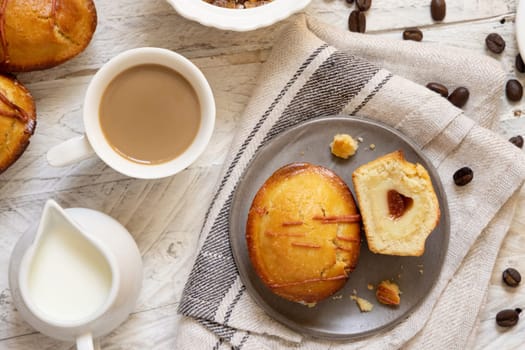Pasticciotto leccese pastry filled with egg custard cream, typical sweet from Lecce, Italy. Pieces of pasticiotto on a beige napkin, apulian breakfast with coffee prepared, top view