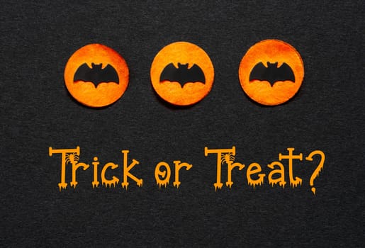 Black Halloween Background With Three Orange Dots With Bats And Text Trick Or Treat