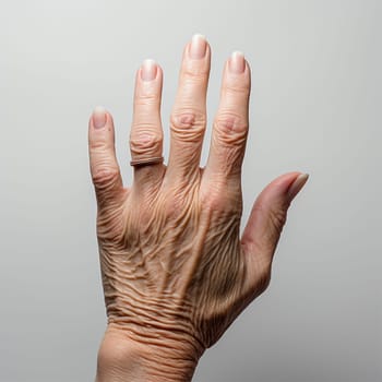 The back of an elderly woman's hand on a light background, wrinkled palms of old women, view of a wrinkled hand