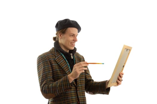 Young smiling artist with a beret on his head on a white background