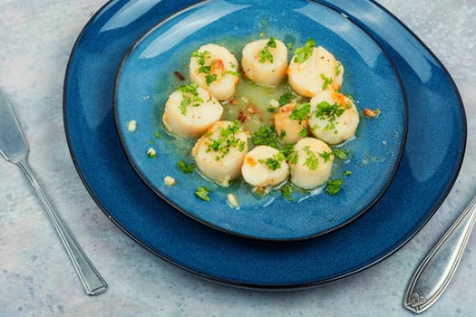 Fried scallops with green on a plate, seafood. Top view.