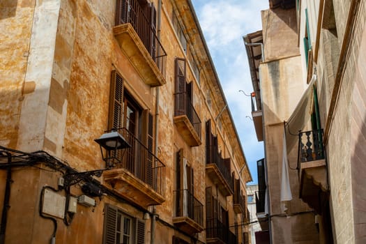 An idyllic scene of Palma de Mallorca old town, an empty narrow street lined with old facades, preserving the timeless charm of this Mediterranean gem. Balearic Islands Spain.