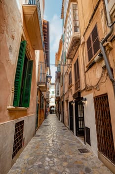 An idyllic scene of Palma de Mallorca old town, an empty narrow street lined with old facades, preserving the timeless charm of this Mediterranean gem. Balearic Islands Spain.