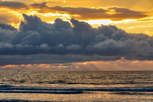 Evening view of the Pacific Coast of Tarcoles in Carara with sunset and glittering waves . romantic sunset landscape. Tarcoles, Costa Rica. Pura Vida concept, travel to exotic tropical country.