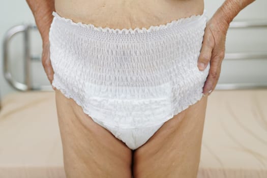Asian elder senior woman patient wearing adult incontinence diaper pad in hospital.