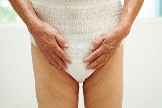 Asian senior woman patient wearing adult incontinence diaper pad in hospital.