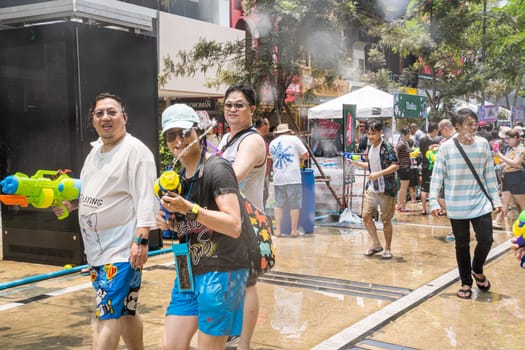 Siam Square, Bangkok, Thailand - APR 13, 2023 Songkran Festival, The short action of people joins celebrations of the Thai New Year or Songkran in Siam Square Bangkok, Thailand.