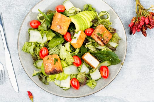 Unusual salad with fried halloumi cheese, vegetables and herbs
